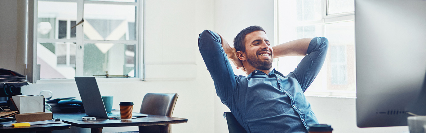 Relaxed business owner in front of computer.